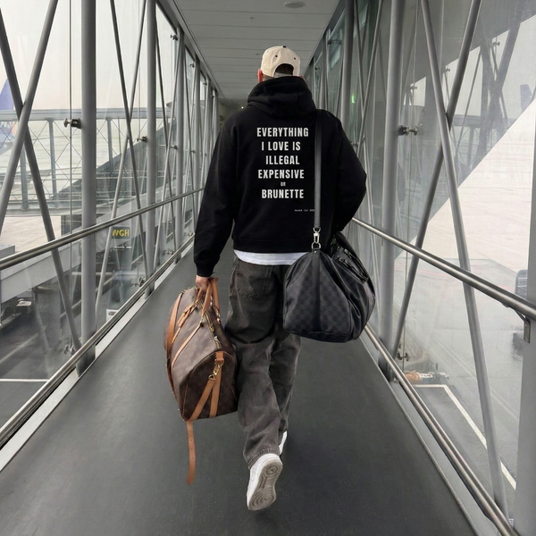 Person walking through a modern building with text on their hoodie