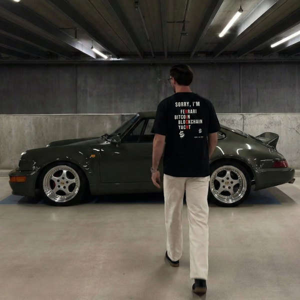 Man walking towards a classic car in an underground parking garage